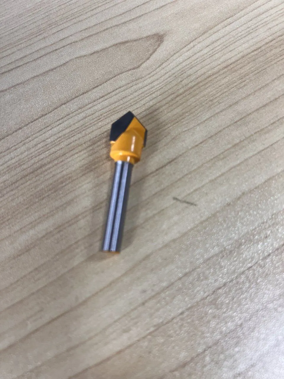 8mm shank 3D V-groove router bit standing on a wood surface